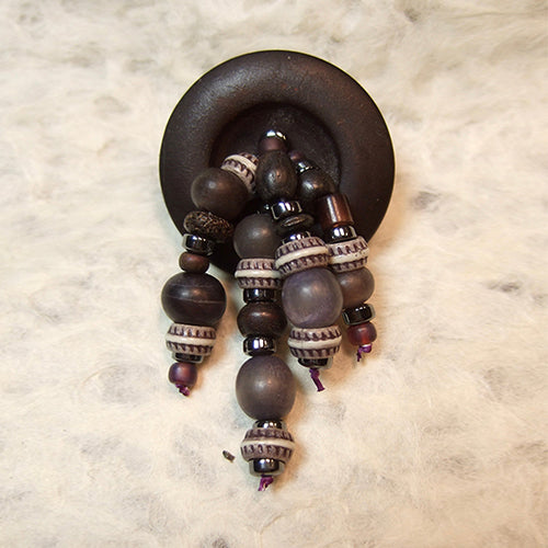 P-88 Hematite, plastic and glass beads on a matte finish button.